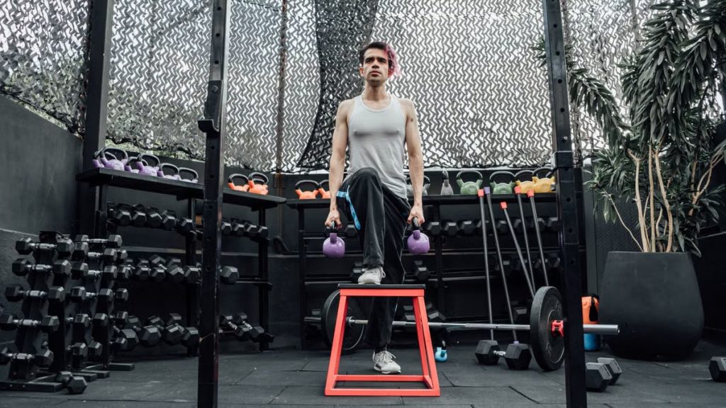 Adult male performing kettlebell exercises in a modern Mexico City gym.